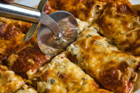 Delicious homemade hot Italian pizza ready to eat. With tomato, ham, mozzarella cheese and four cheeses. Tasteの写真素材