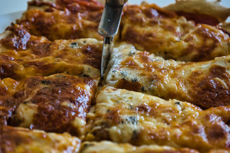 Delicious homemade hot Italian pizza ready to eat. With tomato, ham, mozzarella cheese and four cheeses. Tasteの写真素材