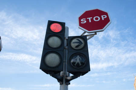 traffic light and traffic sign viewed from below with sky and clouds in the background. view