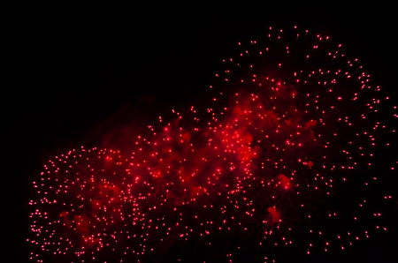 Fireworks and smoke in red color against a black sky as background.の写真素材