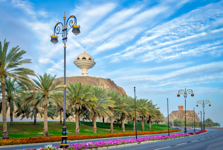 Stylish Streetlights, palm trees and roadside flower beds with the frankincense burner monument in the background.の写真素材