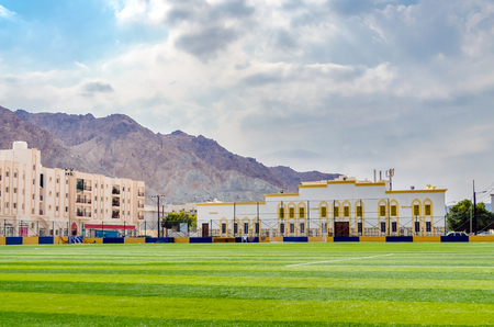 Small football field in Muscat, Oman with buildings and mountains in the background.の写真素材