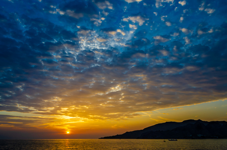 Long shot of dramatic sunrise with intensive cloud coverの写真素材