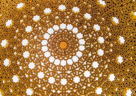 Watching the sky through the intricate patterns of golden gazebo dome in Muscat, Oman.の写真素材