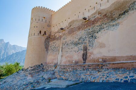 The Magnificent Fort Wall with a watch tower near the mountains and a clear blue sky in the background. From Muscat, Oman.の写真素材