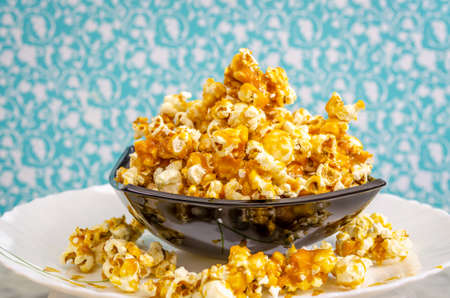 Mound of Sweet Caramel Popcorn in a black bowl.の写真素材