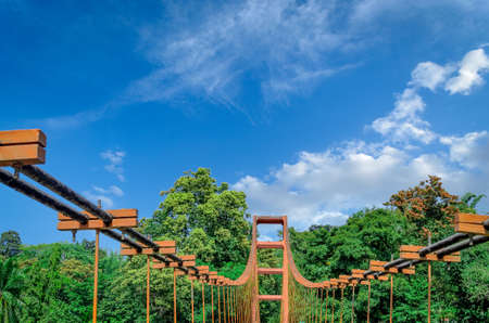 Top of an old, rusty Hanging Bridge in Ezhattumugham, Athirappilly, Kerala, India, with a clear blue sky backgroundの写真素材