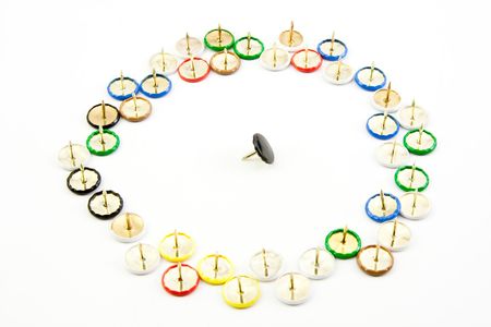 Brightly coloured drawing pins with concept of being surrounded and isolatedの写真素材