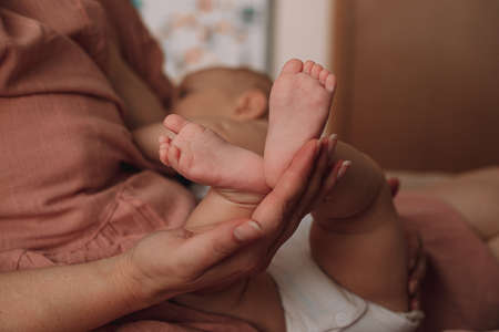 Newborn baby's feet closeup in mommy's hands. Maternity, breastfeeding, expectation motherhood concept.の写真素材