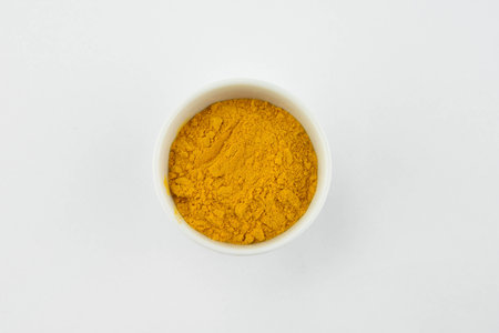 Turmeric spice in white bowl isolated on white backgroundの写真素材