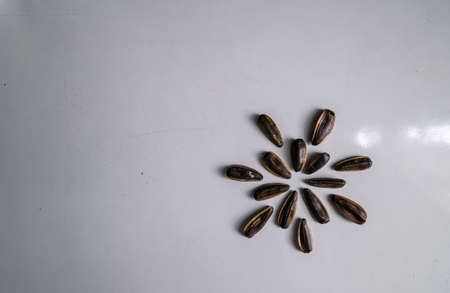 The sunflower seeds are laid out on the ground like a flower.