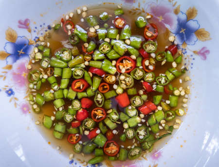 Chili in fish sauce is in a cup as a garnish to add to cooked food.の写真素材