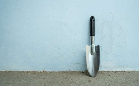 A steel shovel with a black plastic handle is used as a gardening tool.の写真素材