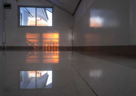 An attic that can fit through the window and has reflection on the floorの写真素材