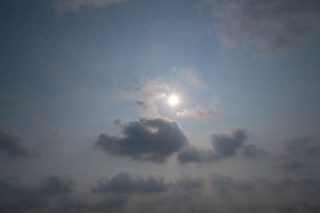 Clouds and the sun look like anglers that emit light on their heads.の写真素材