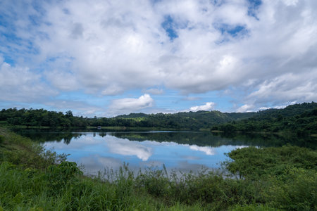 Wang Bon Reservoir, surrounded by trees and mountains, the top part is the sky