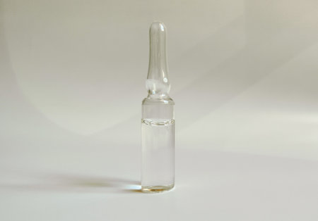 An injection contained in a glass ampoule. on a white background and sunlightの写真素材