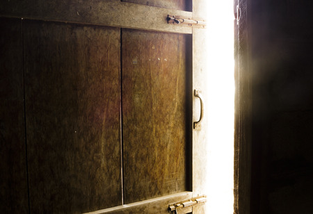 Old dark room with shining closed door.の写真素材