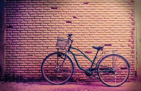 Old rusty vintage bicycle near the concrete wallの写真素材