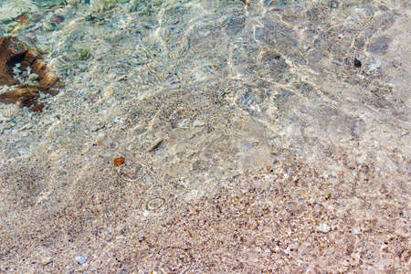 Stone, gravel, sand, crystal clear sea water.