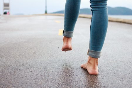 Woman having fun on the street after the rain.
