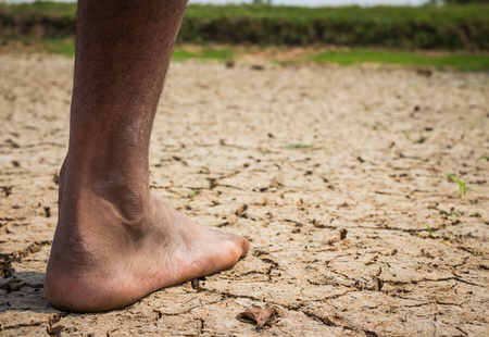 Young man on dry soilの写真素材