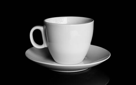 white cup and white saucer with reflection isolated on black backgroundの写真素材
