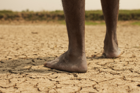 Young man on dry soilの写真素材