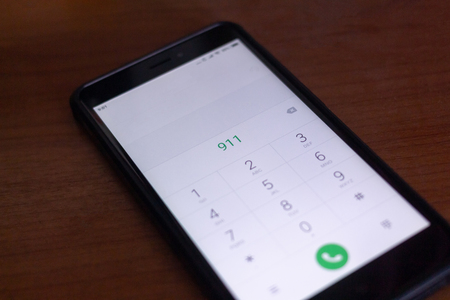 Emergency and urgency, dialing 911 on smartphone screen.