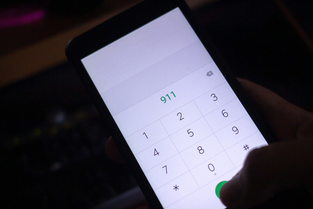 Emergency and urgency, dialing 911 on smartphone screen.