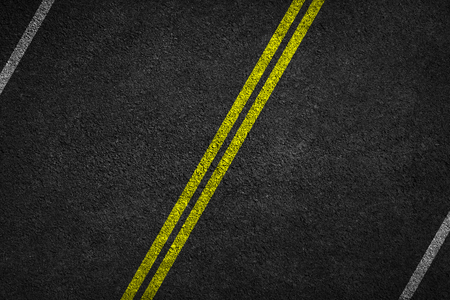 Structure of granular asphalt. Asphalt texture with two yellow line road marking. Abstract road background.の写真素材