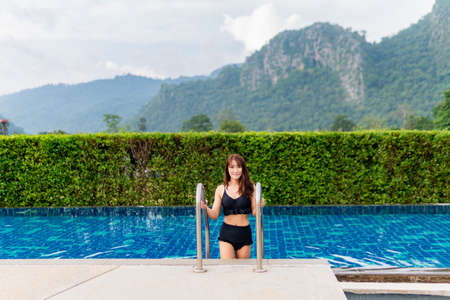 Asia women in the pool In the midst of mountain nature background