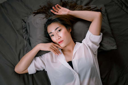 Sexy asian women in white pajamas On a black bed