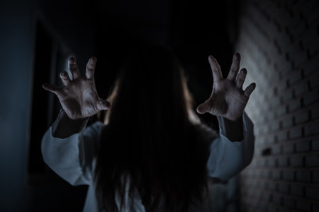 Scary ghost in white dress halloween theme focus hand.