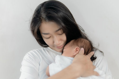 Pretty asia woman holding a newborn baby in her armsの写真素材