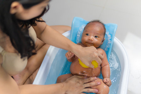 Mother takes a shower, washes newborn baby's hair in the bathroom.