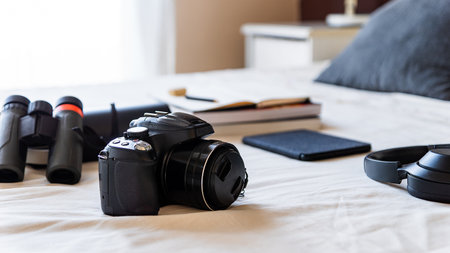 Electronics, books and camera objects organized for a trip