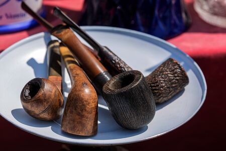 Models of pipes for tobacco smoking on white plate