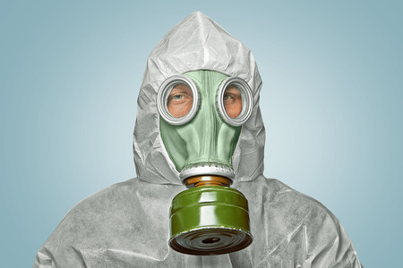 Male scientist in biohazard uniform and gas mask looks at cameraの写真素材