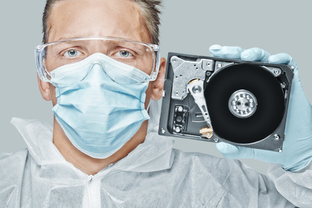 Man technician holds the hard disk and looks at cameraの写真素材