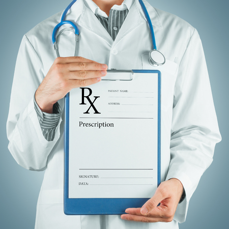 Unrecognizable man doctor gives clipboard with prescription paperの写真素材