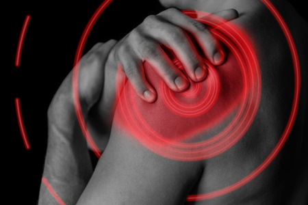 Man compresses his shoulder, pain in the shoulder, black and white image, pain area of red colorの写真素材