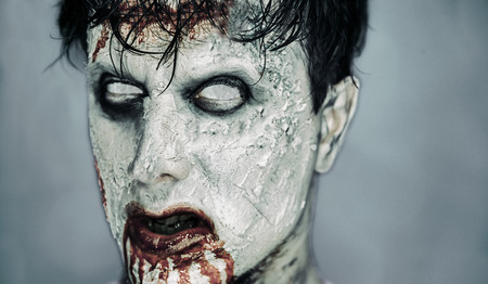 Portrait of scary bloody zombie man with white eyes. Halloween or horror themeの写真素材