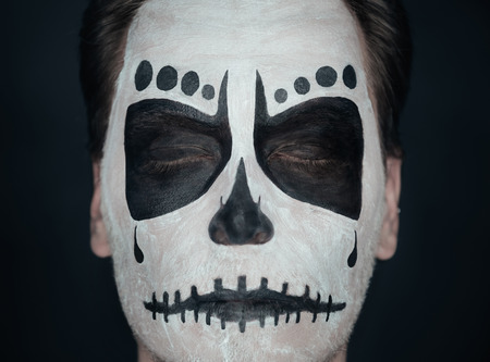 Portrait of young man with closed eyes and sugar skull makeup. Halloween face artの写真素材