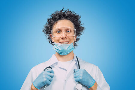 Crazy physician man with stethoscope on blue backgroundの写真素材