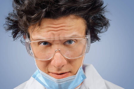 Portrait of crazy surprised man scientist in glasses and maskの写真素材