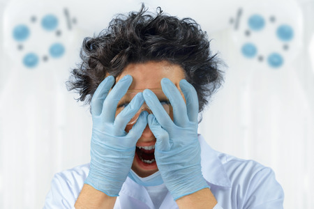 Emotional crazy man doctor holds his faceの写真素材