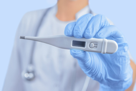 Unrecognizable doctor is showing electron thermometer