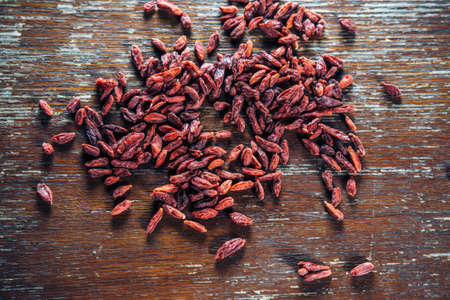 Goji berries are scattered on the wooden tableの写真素材