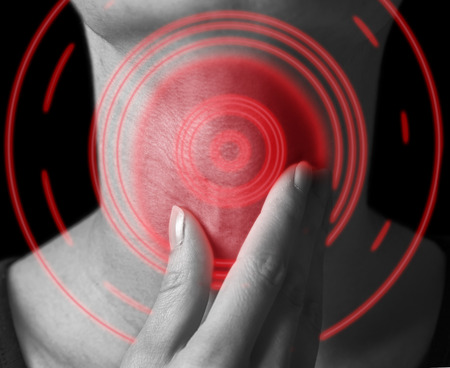 Woman holds her throat, sore throat of red color, monochrome imageの写真素材